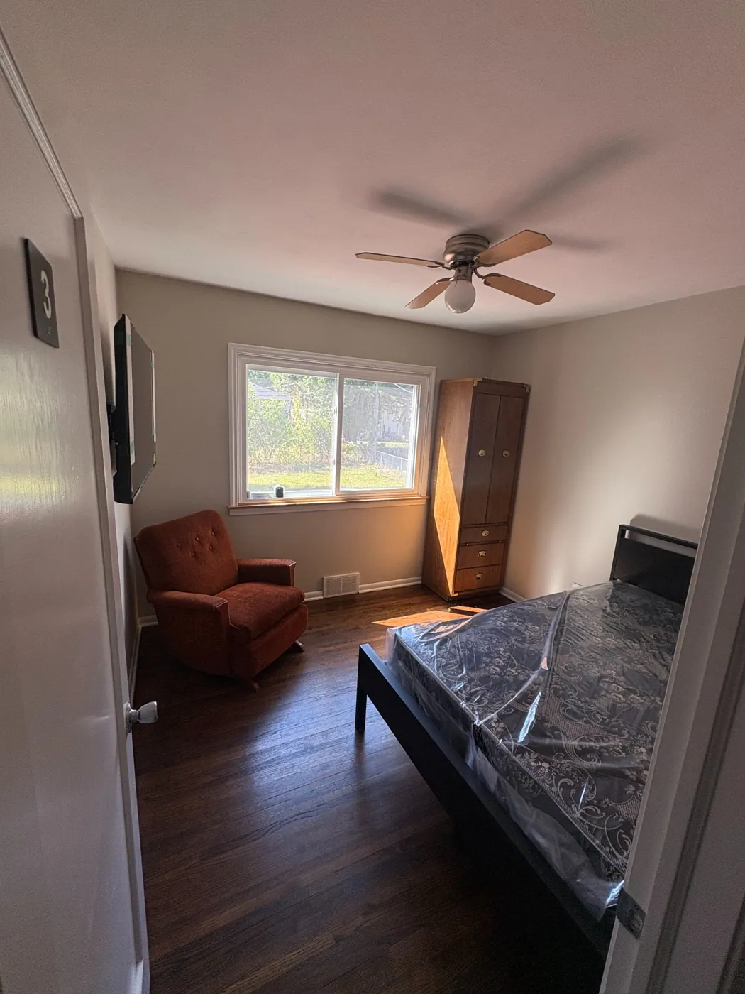 Furnished bedroom with armchair and window